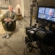 Executive seated in a showroom during a corporate video interview, with the camera and monitor showing the framed shot